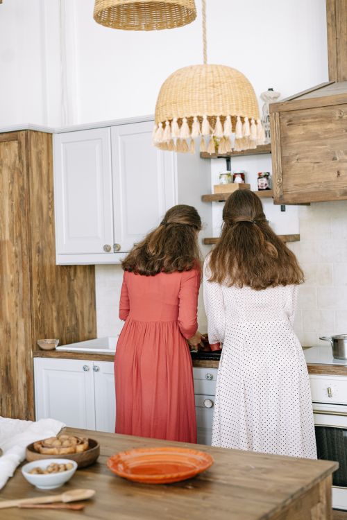 Free Two women in a rustic kitchen preparing food together, creating a cozy atmosphere. Stock Photo