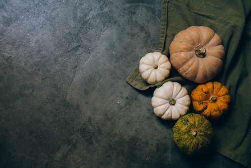 Free Top view of assorted pumpkins on a rustic textured surface, ideal for fall themes. Stock Photo