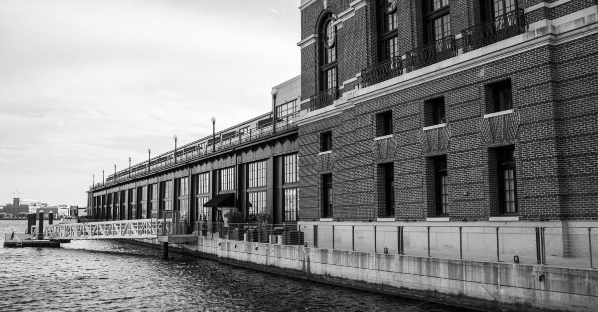 Grayscale image of a historic waterfront building in Baltimore, MD, showcasing urban architecture.