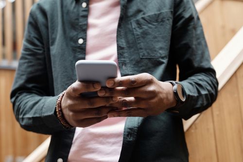 Free Close-up of a man using a smartphone, focusing on hands and device in a relaxed indoor atmosphere. Stock Photo