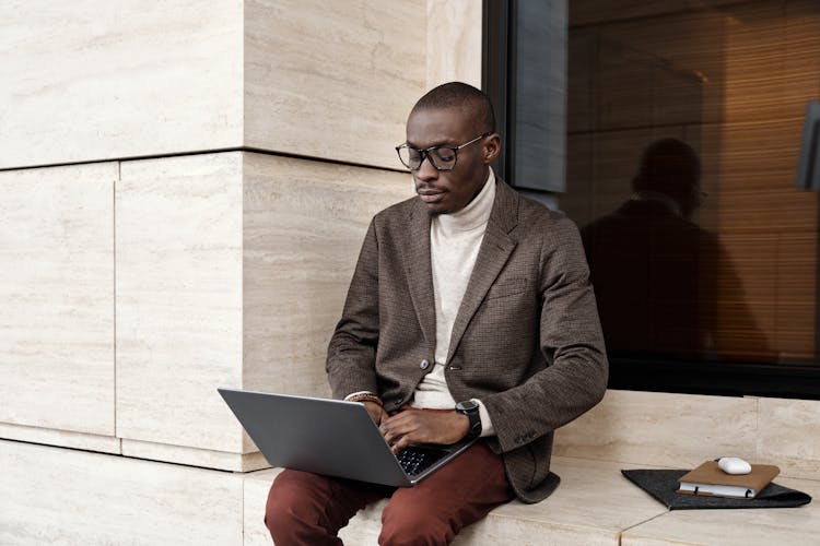 A Stylish Businessman Using A Laptop