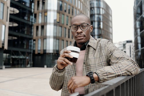 Free A Stylish Businessman Holding a Cup of Coffee Stock Photo