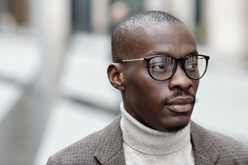 Free Close-up portrait of a man wearing glasses, turtleneck, and houndstooth jacket. Stock Photo