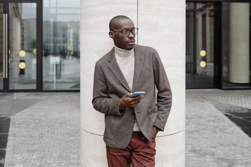 Free A Stylish Businessman Holding a Cellphone Stock Photo