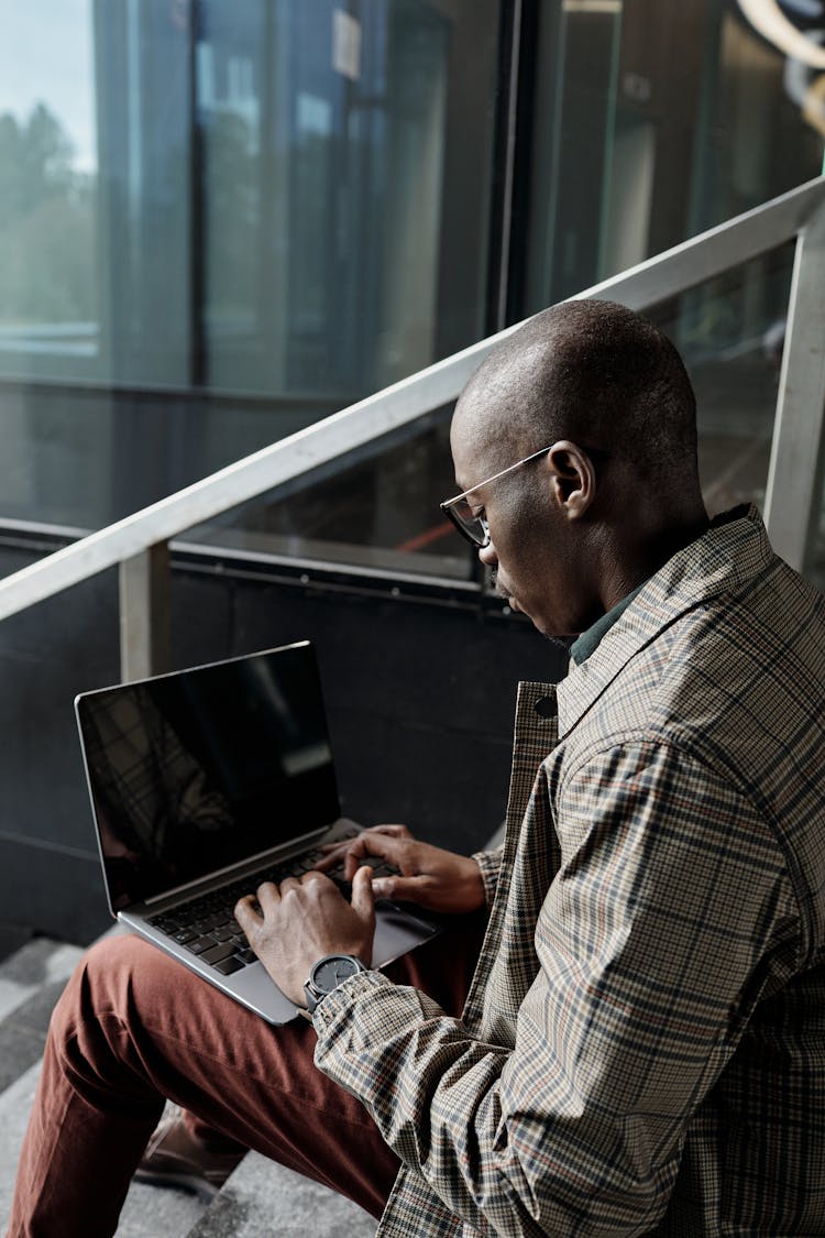 A Stylish Businessman Using A Laptop