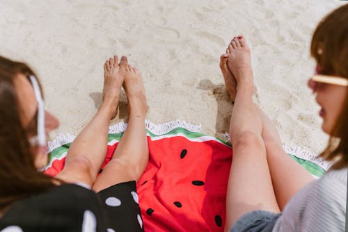 Free Two Person Sitting on Sand While Taking at Daytime Stock Photo