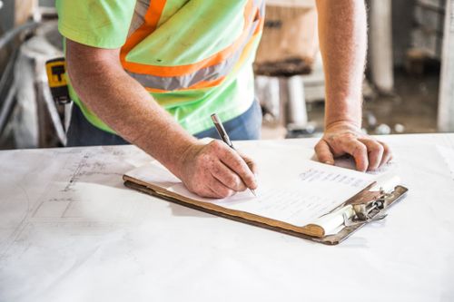 Construction worker writing notes on a clipboard