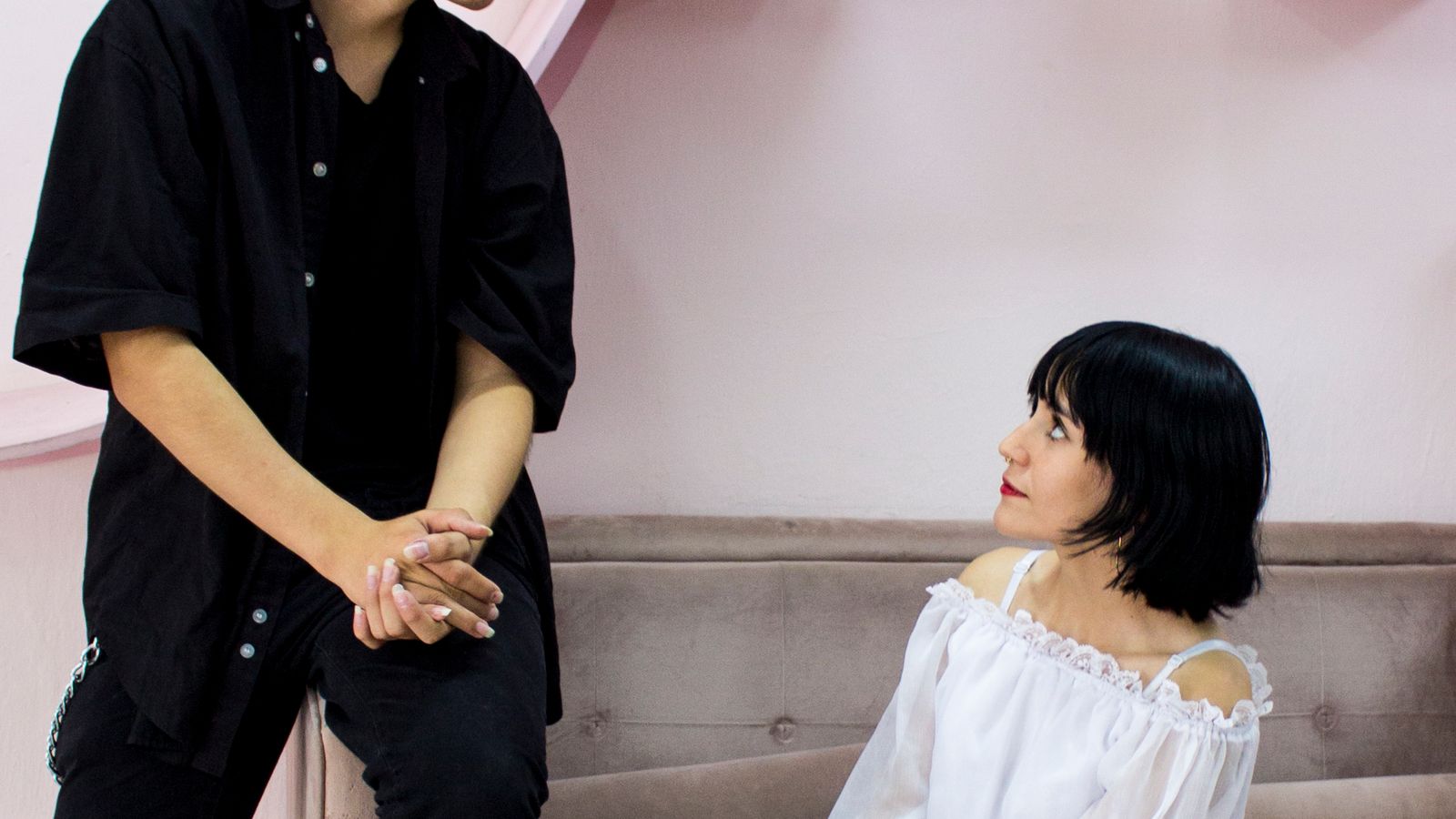 Two adults beside a sofa, one seated and one standing