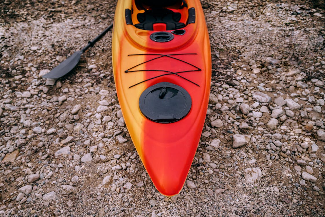 High-Angle Photo of Kayak on Rocky Ground