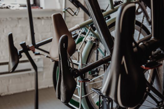 Close-up view of bicycle seats and wheels in an indoor shop setting. Ideal for transportation and bicycle-related themes.