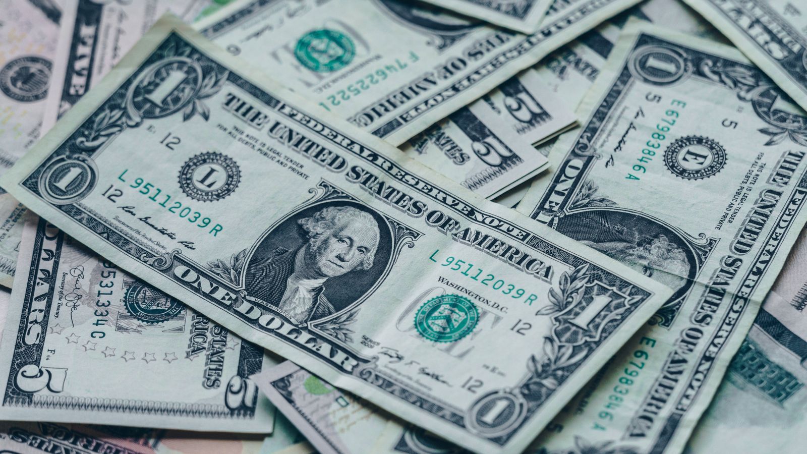 米ドル紙幣が束になって重ねられた様子。国債買い戻しによる通貨供給と円安の仕組みを象徴するイメージ。
