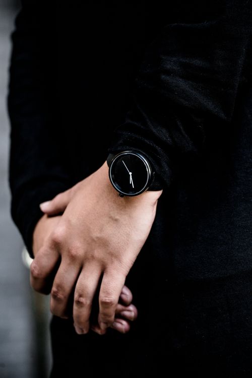 Free Close-up of a stylish black wristwatch on a man's wrist, dressed in dark attire. Stock Photo