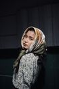 一位年轻女子头戴花卉头巾，时尚肖像中融合了优雅与自信
