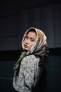 一位年轻女子头戴花卉头巾，时尚肖像中融合了优雅与自信
