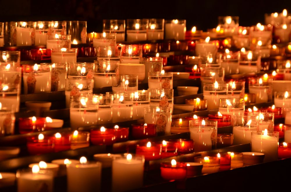 Rows of flickering candles in a chapel