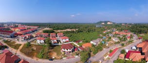 从空中俯瞰，美丽的乡村全景尽收眼底，红屋顶的房屋、绿色植物和清澈的蓝天构成了一幅特色鲜明的画卷