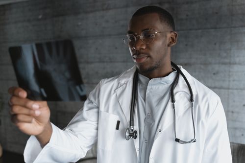 Free Professional doctor with eyeglasses reviewing an X-ray indoors. Stock Photo