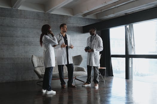 Three doctors in a modern office discussing medical matters in natural light.