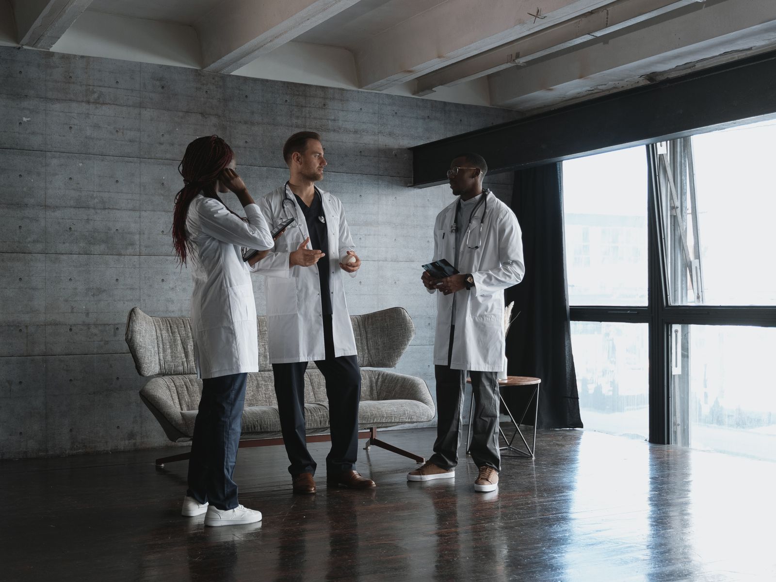 Three doctors discussing work together in a modern office