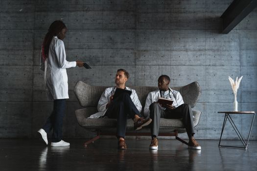 Group of doctors in lab coats having a discussion indoors.