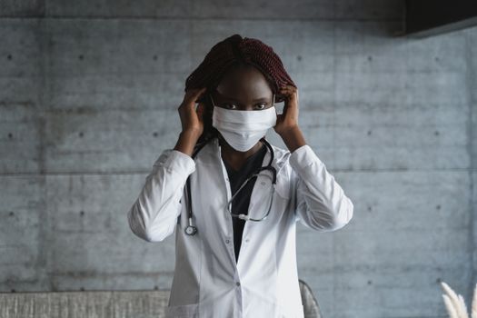 女医护人员在室内调整口罩，展现了医疗专业精神