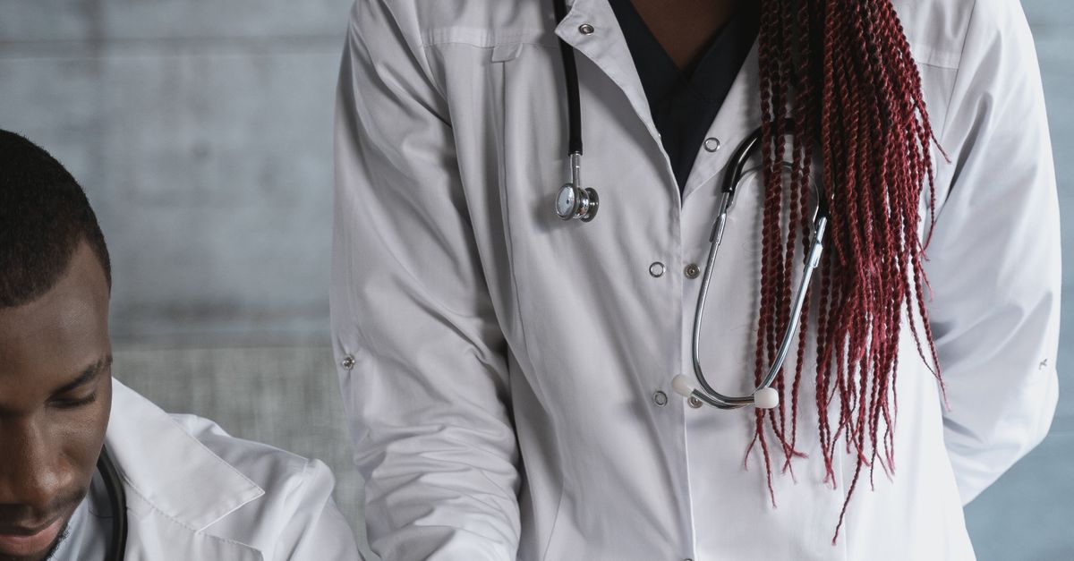 Photo by Tima Miroshnichenko Black male and female doctors collaborating in a medical clinic with a tablet.