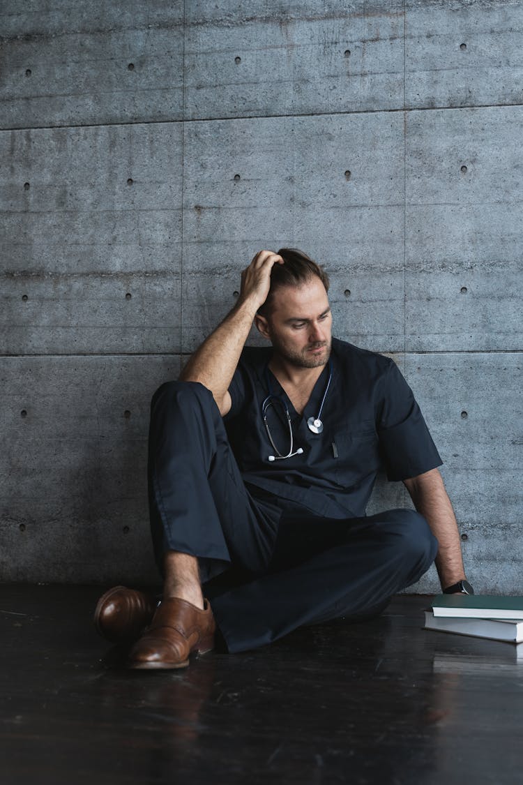 Tired Doctor Sitting On A Floor