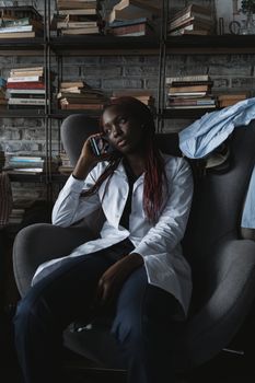 Woman in White Button Up Long Sleeve Shirt Sitting on Black Leather Armchair