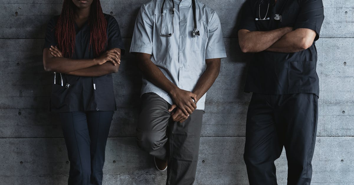 Photo by Tima Miroshnichenko Three diverse healthcare professionals confidently posing in a modern indoor setting.