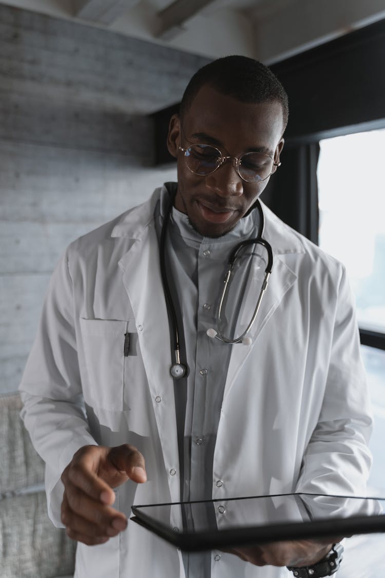 Pensive Doctor Looking At An Ipad 