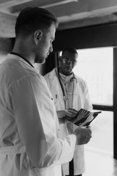 Two doctors studying an X-ray film in a clinical setting.
