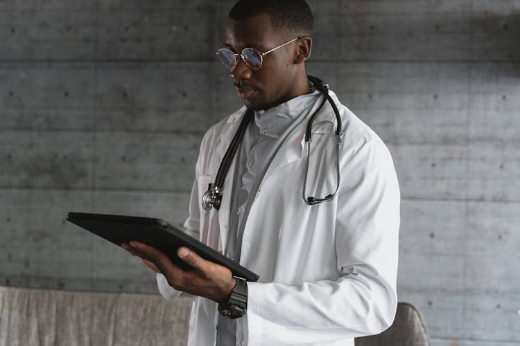 A Doctor Using A Tablet