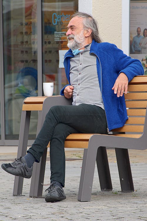 An Elderly Man Wearing Blue Jacket Sitting on a Wooden Bench