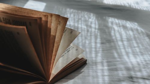 Free Intriguing close-up of an open book with dramatic light and shadow play on the pages. Stock Photo