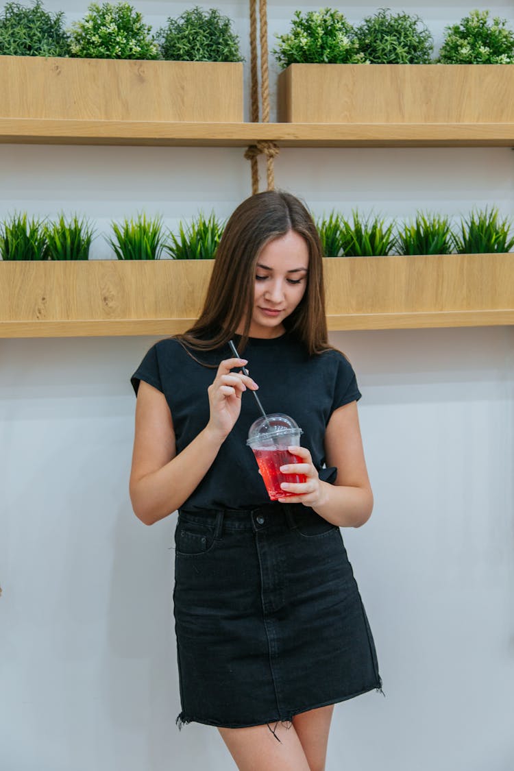 Focused Woman With Plastic Cup Of Drink