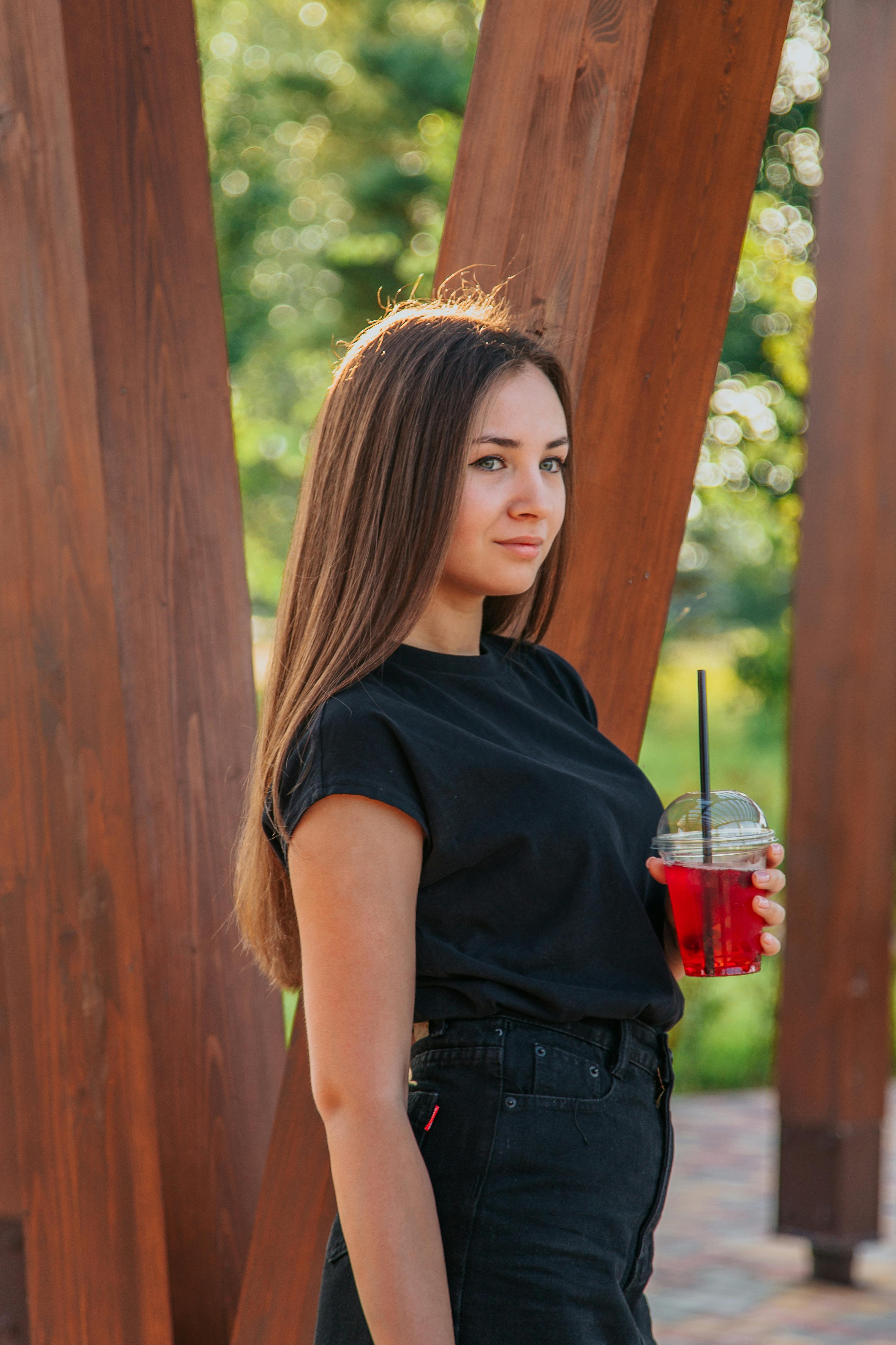 content woman with drink in park