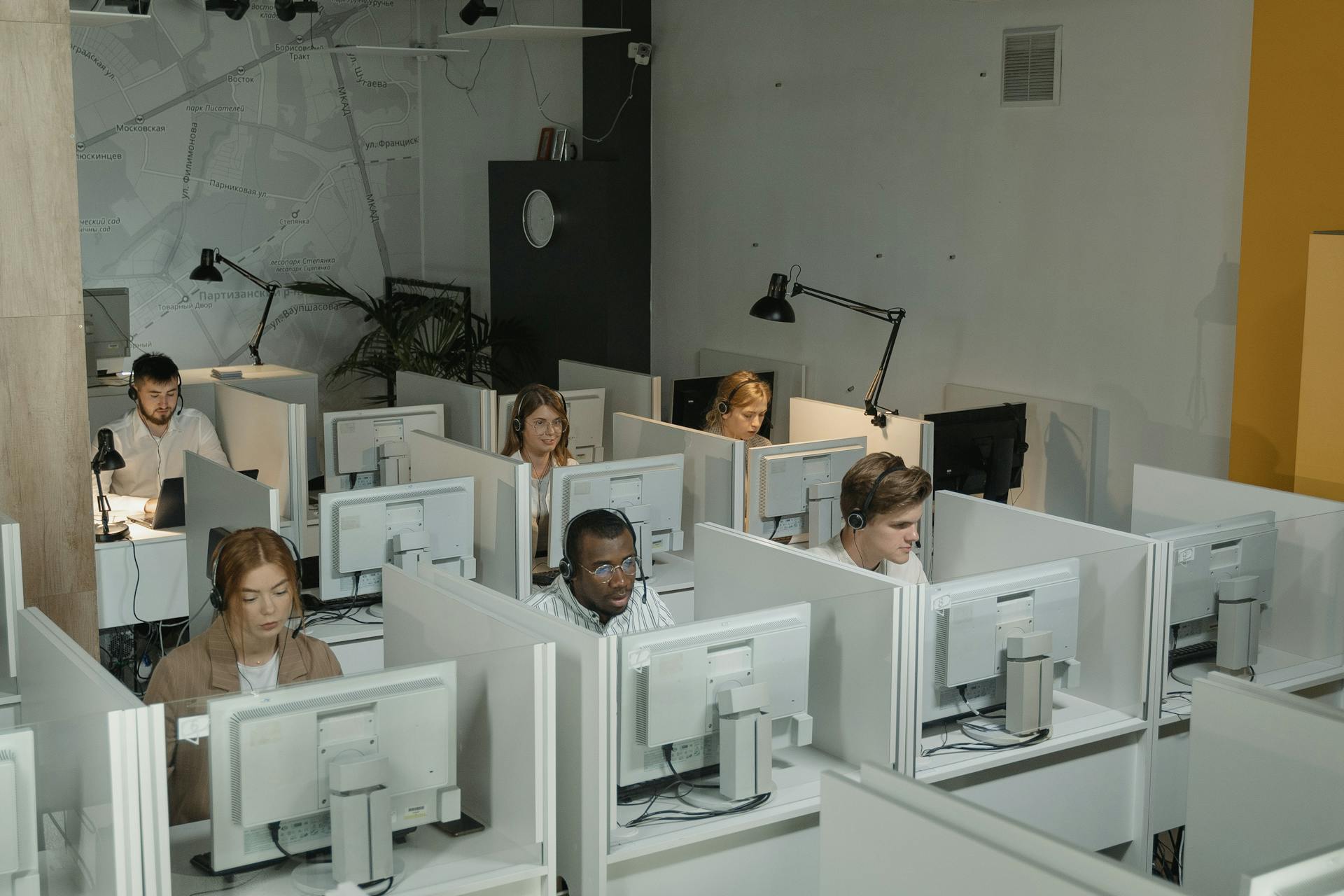 A diverse team of customer service staff working in a modern call center environment.