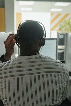 African American man with headset providing customer service in modern call center.