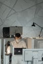 Focused Employee wearing Face Mask in front of a Computer