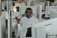 Man Wearing Headphones while Working in Call Center Office