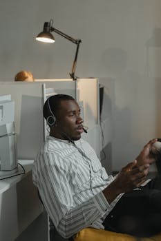 A man in a call center talking on a headset, providing technical support.