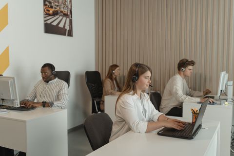 Small business owner holding a phone at a busy service counter