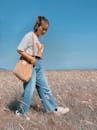 A Woman Walking on the Grass Field