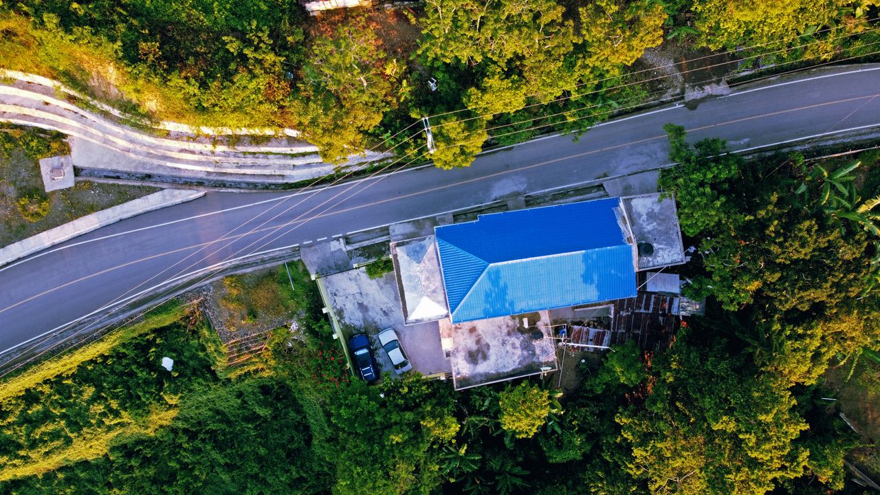 aerial view of a rural house with a blue roof located in moca dominica