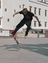 Man in Black T-shirt and Black Pants Doing Skateboard Stunts