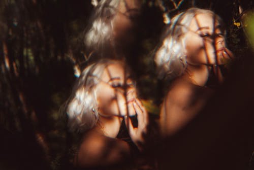 Blonde Woman behind Trees Shadows