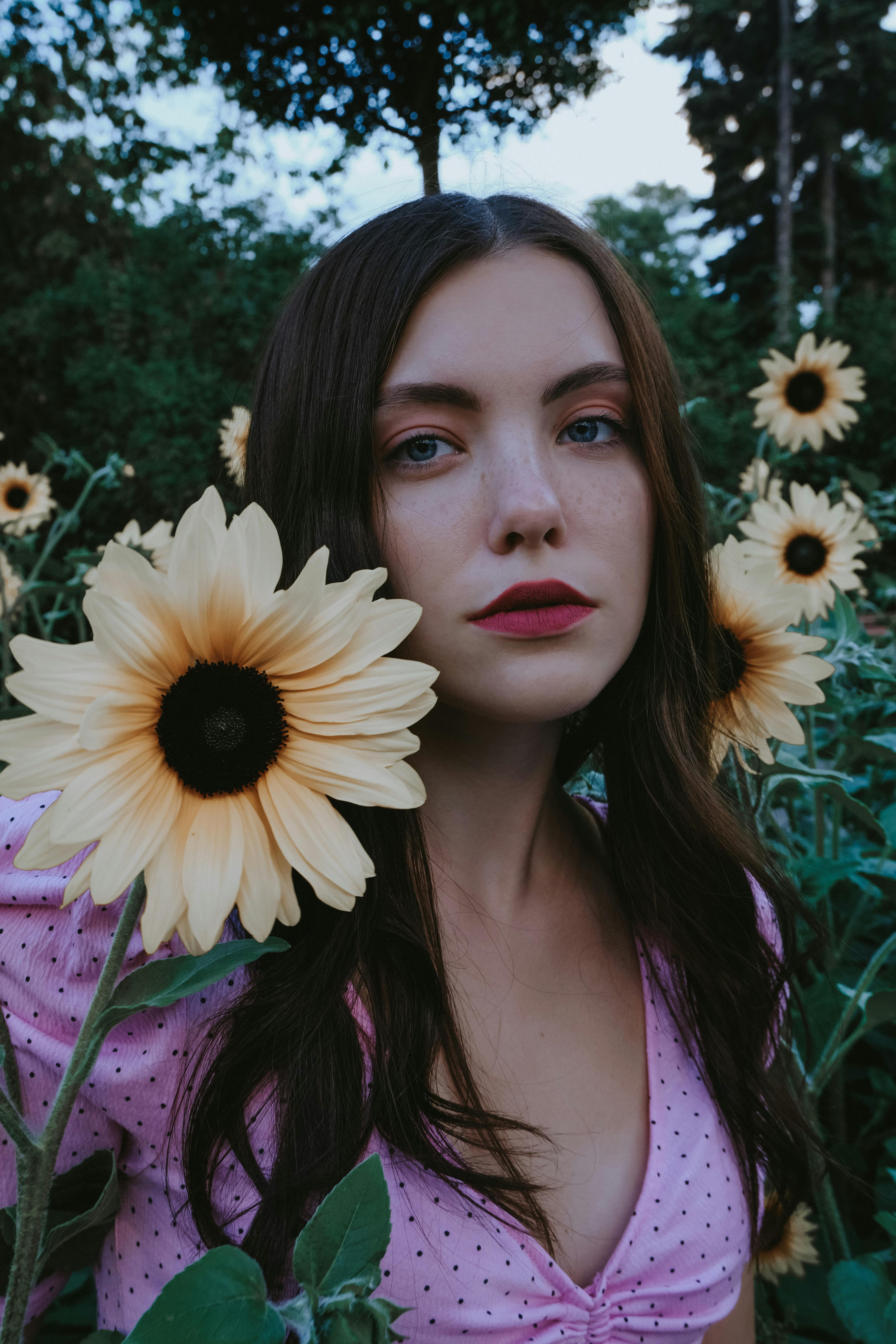 serious pensive woman near gentle flowers