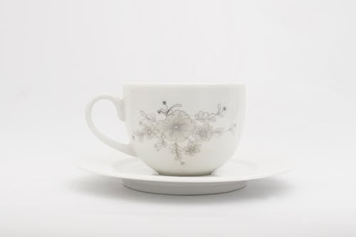 Free White Ceramic Cup with Floral Design on a Saucer Stock Photo