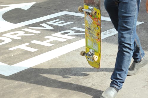 Person Holding Yellow Skateboard