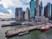Red and White Boat on Dock Near City Buildings